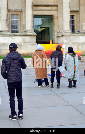 Leute, die an ein sehr farbenfrohes Bild auf dem Trafalgar Square, der National Gallery, London, England, UK. Stockfoto