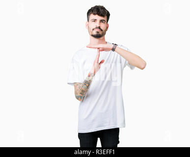 Jungen gutaussehenden Mann tragen weiße T-Shirt über isolierte Hintergrund tun time out Geste mit den Händen, frustriert und ernstes Gesicht Stockfoto