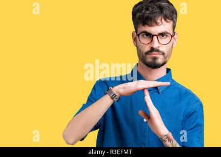 Jungen gutaussehenden Mann Brille über isolierte Hintergrund tun time out Geste mit den Händen, frustriert und ernstes Gesicht Stockfoto