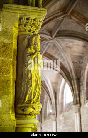 Religiöse Carving im Kreuzgang der Se Evora's Kathedrale beleuchtet durch gelbe Fenster, Evora, Alentejo, Portugal, Europa Stockfoto