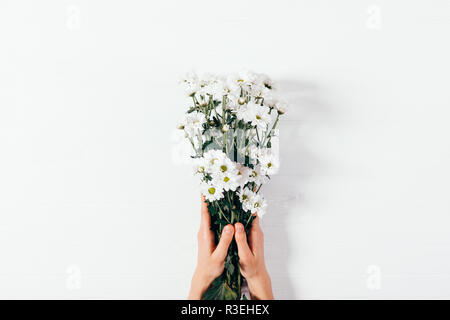 Die Hände oben Frau mit Blumenstrauß, florale Komposition auf weißem Holz- Tisch legen. Stockfoto