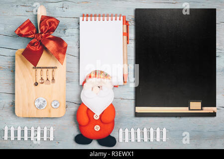 Weihnachten Menü Hintergrund mit Notebook und leere Tafel, Küchengeräte Puppe Santa Claus und Ornamente Stockfoto