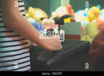 Kleine Mädchen spielen Kralle Kran in Theme Park. Stockfoto