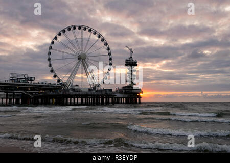 Pier mit Riesenrad an der niederländischen Küste in der Nähe von Den Haag in Scheveningen, Holland. Einer der bekanntesten Orte an der niederländischen Küste. Stockfoto