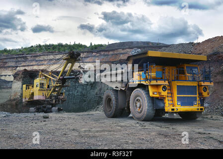 Großen Steinbruch Dump Truck. Laden der Felsen in die Mulde. Laden von Kohle in Body work Truck. Mining Truck Bergbaumaschinen, Kohle vom offenen zum Transport Stockfoto