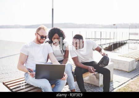 Schönen multi-ethnische Freunde mit einem Laptop in der Straße. Jugend lifestyle Konzept Stockfoto