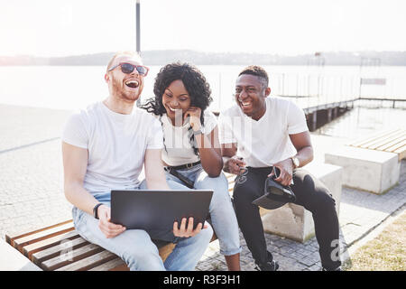 Schönen multi-ethnische Freunde mit einem Laptop in der Straße. Jugend lifestyle Konzept Stockfoto