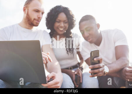 Schönen multi-ethnische Freunde mit einem Laptop in der Straße. Jugend lifestyle Konzept Stockfoto