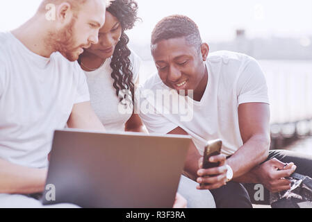 Schönen multi-ethnische Freunde mit einem Laptop in der Straße. Jugend lifestyle Konzept Stockfoto