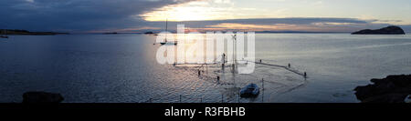 Sonnenuntergang über erhabene North Berwick. Alte Pier nur sichtbar als Flut deckt Oberfläche. Fischer steht auf alte Pier. Stockfoto