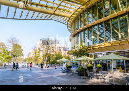 Terrasse des Forum des Halles Shopping Mall im Zentrum von Paris, durch eine große Glaskuppel abgedeckt, mit Kirche Saint-Eustache im Hintergrund. Stockfoto