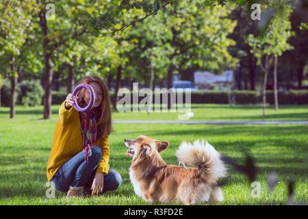 Mädchen und Hund corgi Fuß in den Park Stockfoto