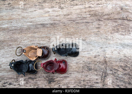 Bunte Leder Schlüsselanhänger in der Form des alten Schuh auf hölzernen Hintergrund Stockfoto