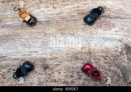 Bunte Leder Schlüsselanhänger in der Form des alten Schuh auf hölzernen Hintergrund Stockfoto