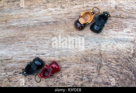 Bunte Leder Schlüsselanhänger in der Form des alten Schuh auf hölzernen Hintergrund Stockfoto