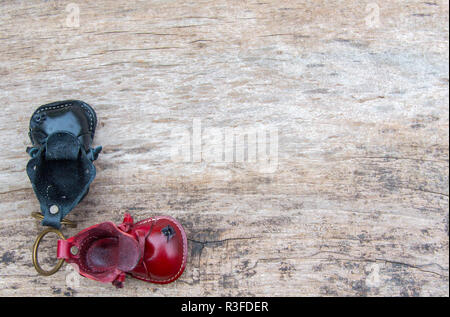 Bunte Leder Schlüsselanhänger in der Form des alten Schuh auf hölzernen Hintergrund Stockfoto