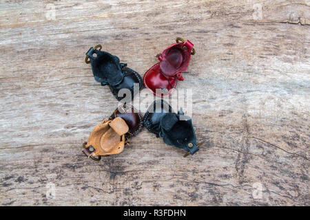 Bunte Leder Schlüsselanhänger in der Form des alten Schuh auf hölzernen Hintergrund Stockfoto