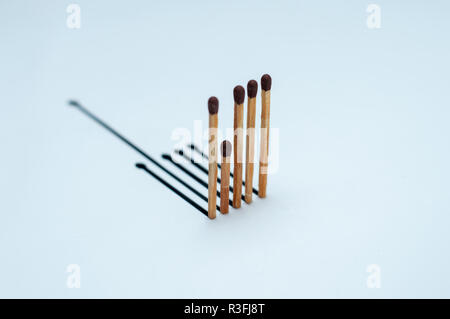 Holz- Übereinstimmungen mit den falschen Schatten auf weißem Papier Stockfoto