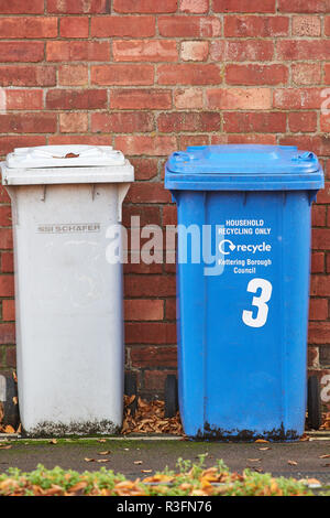 Eine weiße und eine blaue Abfallbehälter, Papierkörbe außerhalb eines Hauses an der Kettering, England. Stockfoto