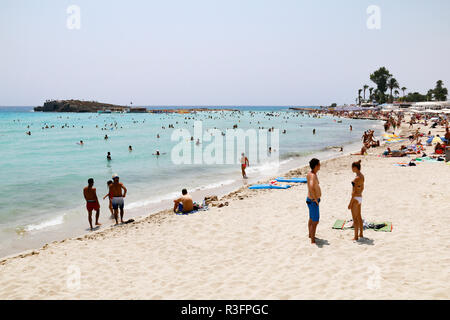 Urlauber entspannen in der Sonne am Nissi Beach, Ayia Napa, Zypern Stockfoto