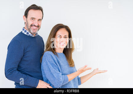 Schönen mittleren Alter Paar in Liebe über isolierte Hintergrund Einladenden natürlichen lächelnd mit offenen Hand eingeben Stockfoto