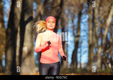 Junge fitness Frau Joggen im Herbst in der Morgen. Attraktives Mädchen auf den Weg in kaltem Wetter zu laufen. Gesunder Lebensstil Bild mit Kopie Raum Stockfoto