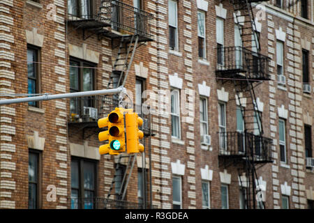 Nahaufnahme einer Ampel und einige Gebäude im Hintergrund mit Fenster und Treppen. Bezirk Bronx, New York, USA. Stockfoto