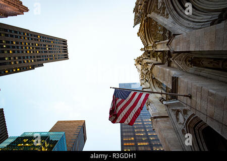 NEY YORK-USA - 03. NOVEMBER 2017. Eine amerikanische Flagge weht auf eine Kirche in Manhattan. Manhattan oft lokal wie die Stadt genannt, ist die am meisten de Stockfoto