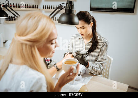 Blonde Nagel Künstler Gefühl besetzt, das Maschine Maniküre Stockfoto