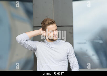 Haarschnitt Konzept. Mann mit modischen Haarschnitt. Junger Mann mit neuer Frisur. Hübscher Kerl touch Haare Haarschnitt. Ein Schnitt über dem Rest. Stockfoto