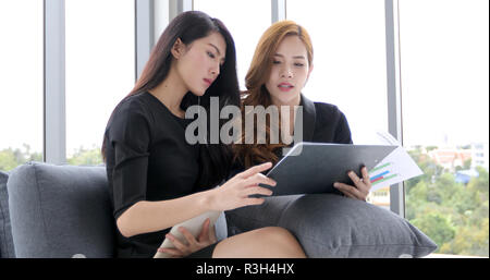 Unternehmerinnen mit Notebook und Tablet für die Diskussion von Dokumenten und Ideen im Meeting und Business ernsthaft für die Arbeit Stockfoto