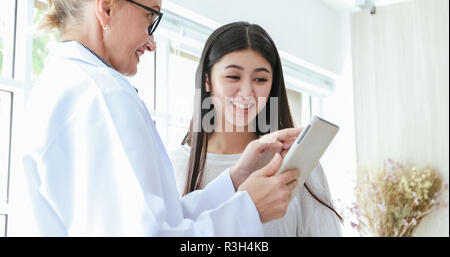 Arzt und Patient erklären, Medikation, die Frau in seinem Büro in Krankenhäusern Stockfoto