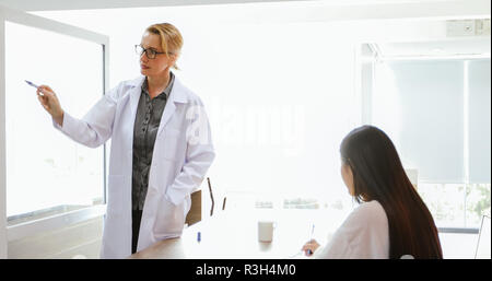 Ärzte oder Wissenschaftler lehren und erklären, Studenten und Patienten Schreiben an Bord Stockfoto