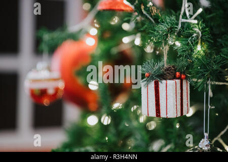 Frohes neues Jahr und Verzierungen auf den Weihnachtsbaum mit Geschenkbox, verschwommen und Soft Focus Stockfoto