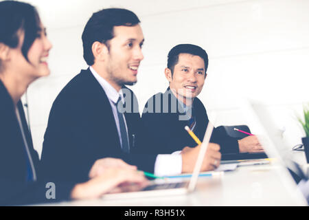 Asiatische Geschäftsleute und Gruppe mit Notebook für Business Partner Dokumente zu diskutieren und Ideen zu treffen und Business Frauen Lächeln glücklich für workin Stockfoto