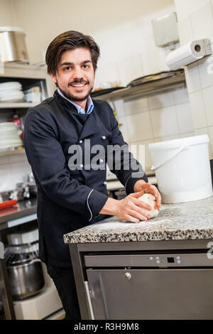 Junge Küchenchef im Teig werfen Pizzateig Pizza Bäcker Stockfoto