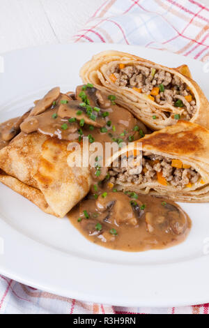 Pfannkuchen crepes Tortillas gefüllt mit Pilzen und Hackfleisch auf einer weißen Platte Stockfoto