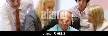 Der Chefkoch und sein Team zusammen mit dem Monitor Stockfoto