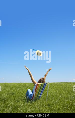 Junge Frau sonnt sich im Liegestuhl Stockfoto