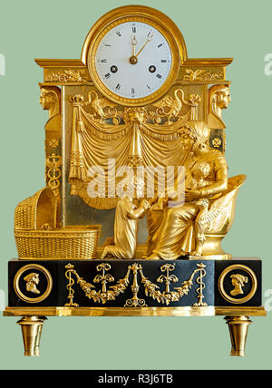 Antike Pendule mit goldenen Statuetten von einer Frau und Kinder auf isolierten grüner Hintergrund mit Freistellungspfaden. Stockfoto