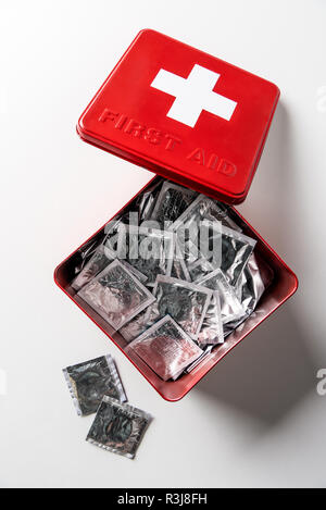 Blick von oben auf die Erste Hilfe Kit Red Box mit silber Kondome isoliert auf weißem Stockfoto