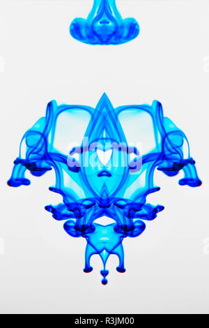 Lebensmittelfarbe in Glas Wasser und Dispergieren. Stockfoto