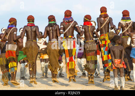 Afrika, Äthiopien, südlichen Omo Valley, Nyangatom Stamm. Sowohl Männer als auch Frauen melden Sie gemeinsam am Tanz zu springen. Stockfoto