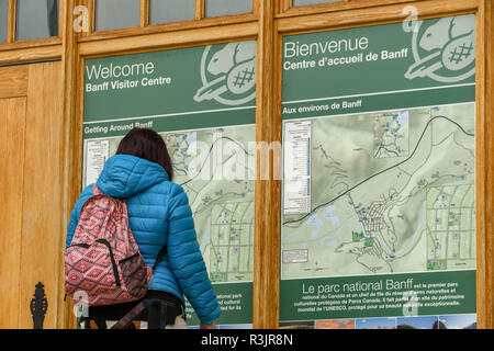 BANFF, AB, Kanada - Juni 2018: Gast Studium eine große Karte angezeigt an der vorderen Wand des Banff National Park Visitor Centre in Banff. Stockfoto