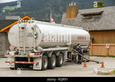 BANFF, AB, Kanada - Juni 2018: Arbeitnehmer, die einen Tanker zu einer Tankstelle in Banff Stadtzentrum. Stockfoto