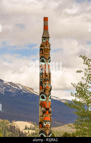 JASPER, AB, Kanada - Juni 2018: Totem Pol in der Nähe des Zentrum von Jasper, Alberta, mit Bergen im Hintergrund. Stockfoto