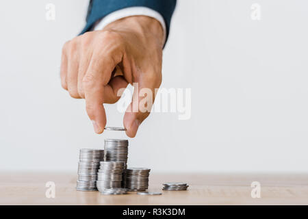 Männliche handpflückung Silber münze aus Holz- Tabelle Stockfoto
