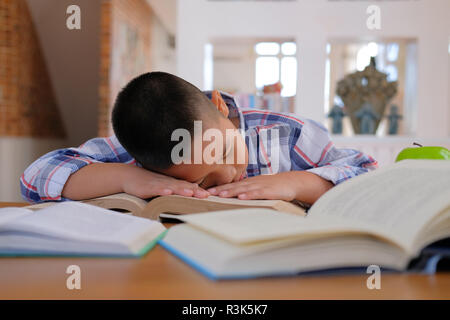 Faul betont Jungen kleinen asiatischen kid Boy ruhen Schlafen auf Schreibtisch. Kind einschlafen. Kinder aus dem Studium im Klassenzimmer müde. Kindheit Bildung Stockfoto