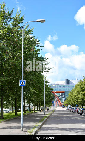 Gerade Straße entlang mit einem Fußweg, Parkplätze auf der rechten Seite der Straße; sonniger Tag in Helsinki, Finnland Stockfoto