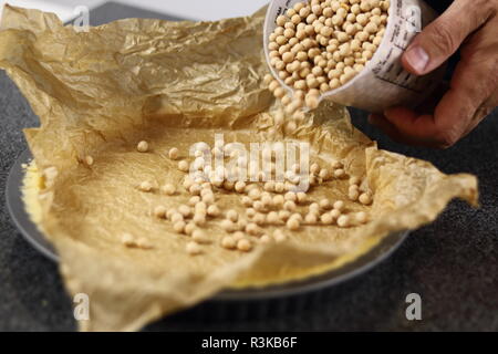 Hinzufügen Backbohnen in Blätterteig. Schokolade, Birne und Pecan Pie Serie. Stockfoto